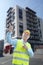Friendly constructor pointing index fingers building background
