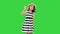 Friendly cute cheerful asian school girl waving hi to the camera on a Green Screen, Chroma Key.