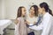 Friendly doctor listening to young patient`s breath during medical checkup at the clinic