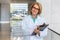 Friendly doctor physician lifestyle portrait, smiling at medical hospital workplace while writing on clipboard