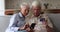 Friendly elderly couple make purchase online using phone pension card