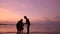 Friendly family hugs and kisses on the tropical beach at the sunset time. Happy family concept. Active people on summer vacations