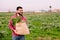 Friendly farmer with a burlap bag with vegetables