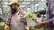 Friendly farmer giving box of fresh vegetables to customer, agriculture business