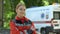 Friendly female paramedic posing for camera, ambulance on background, save lives