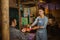 friendly female stall keeper with apron serving food and drinks