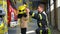 Friendly firefighter puts a protective helmet to a little boy