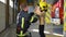 Friendly firefighter puts a protective helmet to a little boy