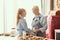 Friendly girl and granny having conversation while eating at kitchen