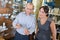 Friendly hardware store assistant helping woman choosing taps