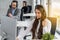 Friendly helpline operator woman with headset in call center.