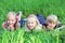 Friendly kids lying on green grass in summer park