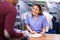 Friendly laundry worker talking to customers at reception