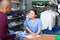 Friendly laundry worker talking to customers at reception