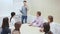 Friendly lawyer sitting with laptop in informal office meeting space, consulting his young female clients