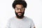 Friendly-looking outgoing and nice african american bearded male digital nomad in glasses with afro hairstyle smiling