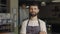 Friendly male bartender posing with crossed arms at cafe