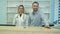 Friendly male and female nurses behind reception desk in hospital