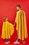 Friendly man and kid girl in yellow cloaks, pretend to be superheroes