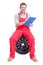 Friendly mechanic holding clipboard and sitting on tire