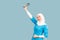 A friendly, muslim doctor or nurse woman in hijab with a stethoscope on a blue background. emotions of victory or success