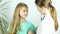 Friendly pediatrician doctor examines a girl with stethoscope checking lungs