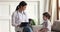 Friendly pediatrician giving high five to small child boy patient.