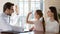 Friendly pediatrician and smiling little girl giving high five