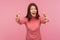 Friendly positive brunette woman in pink sweater stretching hands ready to cuddle looking at camera with happiness, free hugs