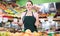 Friendly  salesgirl proposing fresh fruits and vegetables in supermarket