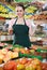 Friendly salesgirl proposing fresh fruits and vegetables in supermarket