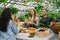 Friendly saleswoman selling organic vegetables during farm sale in greenhouse