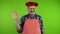 Friendly senior chef in red apron waves palm for greeting or goodbye sign.
