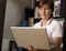 Friendly senior woman standing with laptop