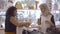 Friendly shop cashier folding clothes and packing paper bag