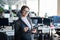 A friendly support woman with glasses and a business suit is talking on a headset with a customer. A girl with a folder