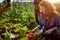 Friendly team harvesting fresh vegetables from the rooftop greenhouse garden and planning harvest season on a digital