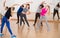 Friendly teenage boys and girls learning in dance hall