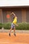 Friendly tennis match - a boy jumps to serve the ball
