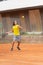 Friendly tennis match - a boy in yellow shirt takes the ball