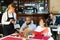 Friendly waitress in protective mask takes the order of restaurant visitors