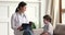 Friendly woman pediatrician and child boy talk at pediatric checkup