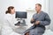 Friendly woman uzist advises male patient in clinic