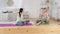 Friendly yoga trainer teaching young women to stretch her body