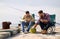 Friends adjusting fishing rods with bait on pier