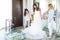 Friends Adjusting Wedding Gown For Woman