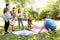 Friends arranging place for picnic at summer park