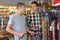 Friends buying guitar strap in guitar shop