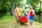 Friends carrying kayak or canoe to forest river