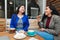 Friends and Coffee: Cafe Patio Hosts Two Young Latina Women Enjoying Coffee and Sweet Pastries